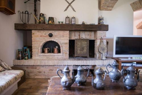 uma sala de estar com uma lareira de tijolos e uma televisão em Villa con piscina in Abruzzo - A 7 minuti dal Mare em Ripa Teatina