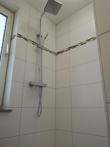 a shower with a shower head in a bathroom at Lüdenscheid-Ferienwohnung de Betzler Weh29-100 in Lüdenscheid