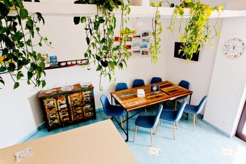 una sala da pranzo con tavolo in legno e sedie blu di B&B Shining ad Avola