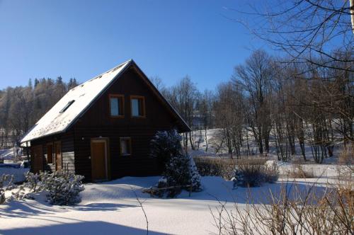 a small wooden house with snow on the roof at Chaty Javorina in Javorina