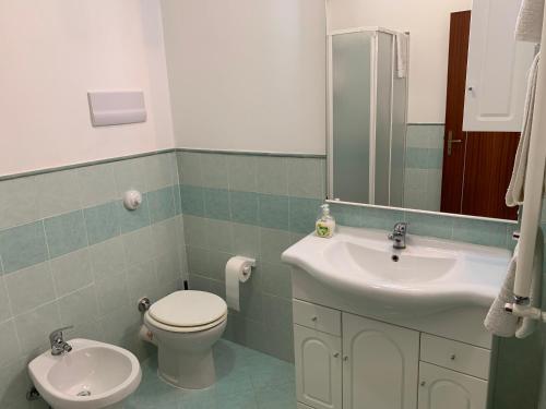 a bathroom with a sink and a toilet and a mirror at casavacanzabordonaro in Palermo