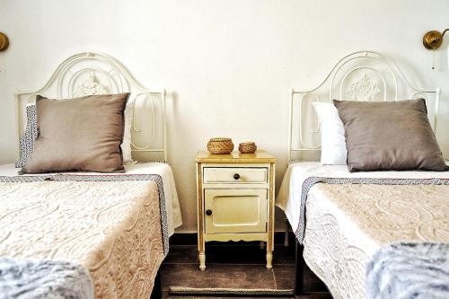 a bedroom with two beds and a nightstand between them at Recanto do Ti Zé in Aldeia do Mato