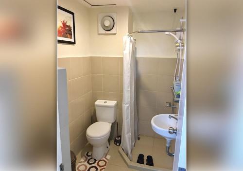 a bathroom with a toilet and a sink at Davao Condo 2BR Pool Wifi Netflix in Davao City