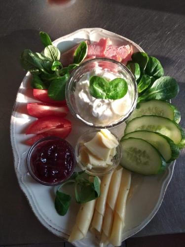 a plate of food with cheese and dip and vegetables at Oberża Złota Gęś in Siewierz