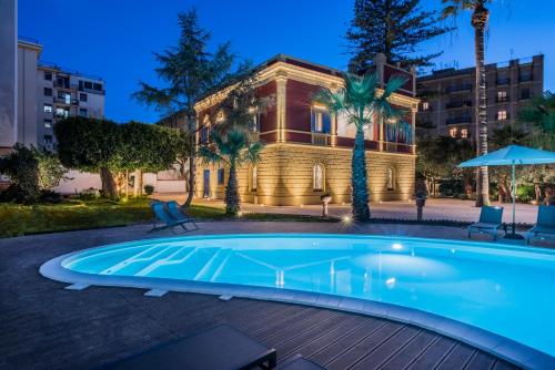 a swimming pool in front of a building at Giardini Mon Plaisir in Trapani