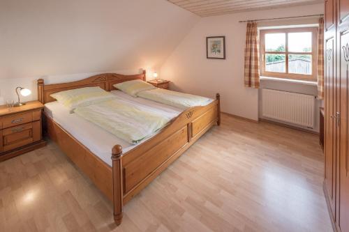 a bedroom with a large wooden bed and a window at Schelterhof in Wunsiedel