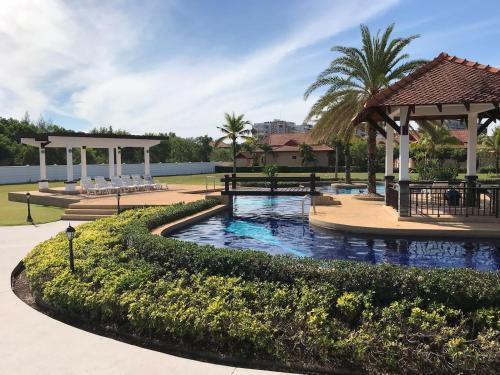 a pool in a park with two benches and a pavilion at Mae Phim -Beachfront living in a villa with a private pool ! in Ban Tha Fat