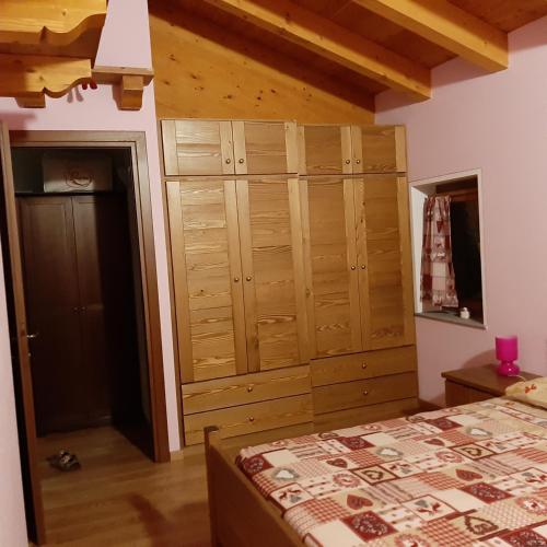 a bedroom with a bed and a large wooden closet at Maison Venoir1 in Aymavilles