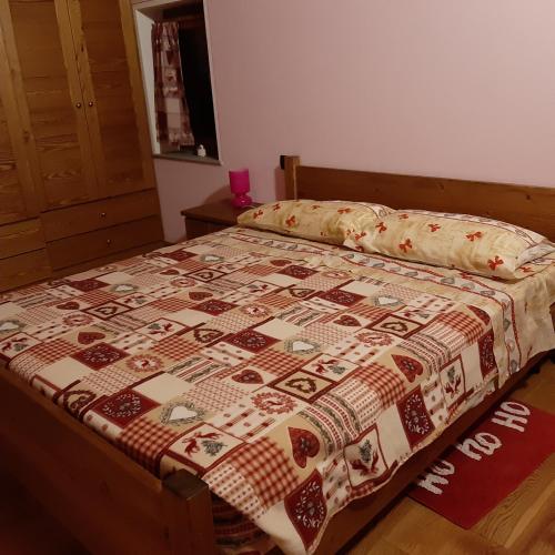 a bed with a quilt on it in a bedroom at Maison Venoir1 in Aymavilles