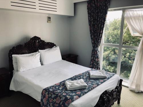 um quarto com uma cama com lençóis brancos e uma janela em My Place Hotel em Londres