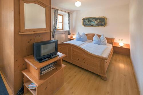 a bedroom with a bed with a tv in it at Schelterhof in Wunsiedel