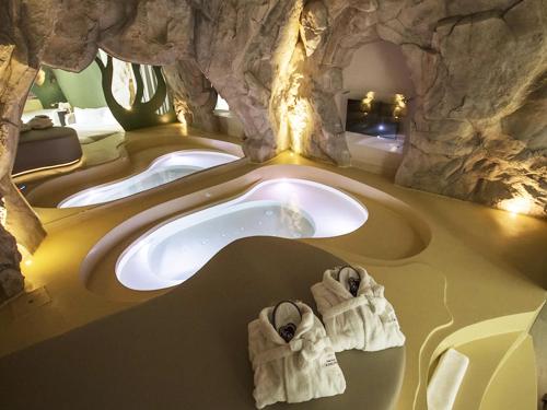 Baño con 3 lavabos en una cueva en Emotional Grand Motel, en Fontaneto dʼAgogna