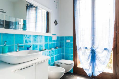 a blue and white bathroom with a toilet and a sink at Casa↨di Amore e Psiche in Verona