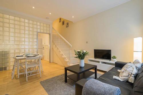 una sala de estar con un sofá y una mesa en 2BR Grassmarket Apartment with Castle View, en Edimburgo