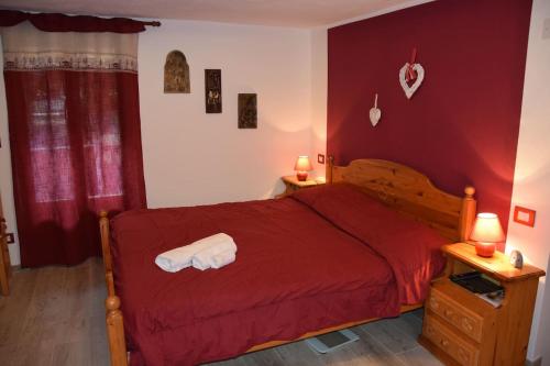 a bedroom with a red bed with towels on it at Chez Elida in Saint-Christophe