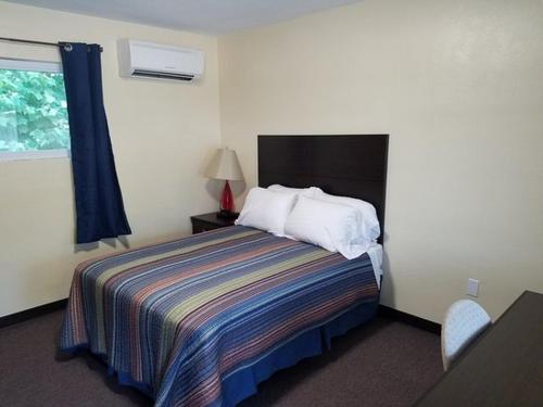 a hotel room with a bed and a window at Windsor Crossroads Motel in Windsor