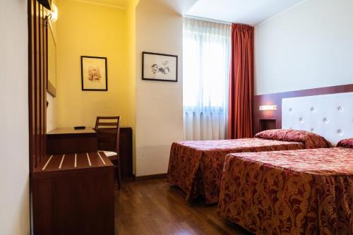 a hotel room with two beds and a window at Hotel Villa Venus Resort & SPA in Atena Lucana