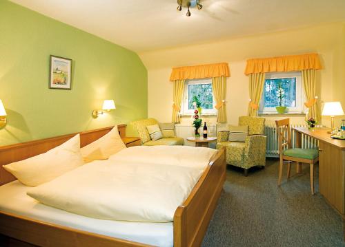ヴィーツェンドルフにあるBrammers Landhotel Zum Wietzetalのベッドルーム1室(ベッド1台付)、リビングルームが備わります。