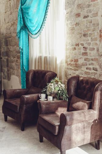 a living room with two leather chairs and a window at Benjamin Hotel in Kaštela