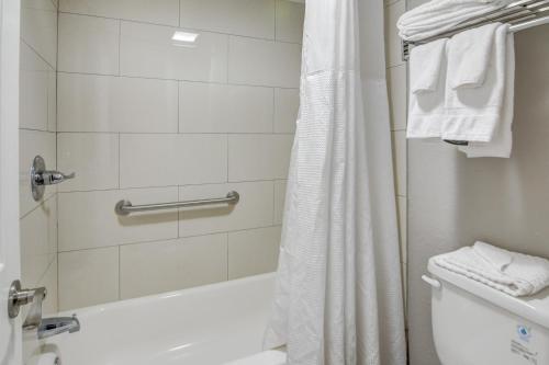 a bathroom with a shower and a white tub at Seabreeze Inn - Fort Walton in Fort Walton Beach