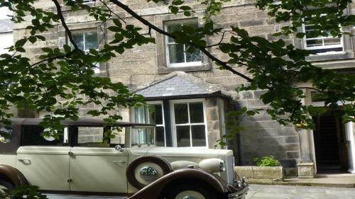 an old car parked in front of a building at The Orchard House in Rothbury