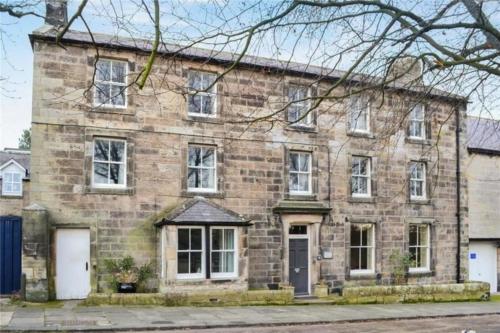 a large brick house with white doors and windows at The Orchard House in Rothbury