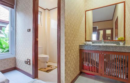 a bathroom with a sink and a toilet and a mirror at Thai style villa with very beautiful private pool in Kamala Beach