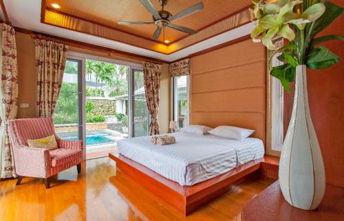 a bedroom with a bed and a vase with a cat on it at Thai style villa with very beautiful private pool in Kamala Beach