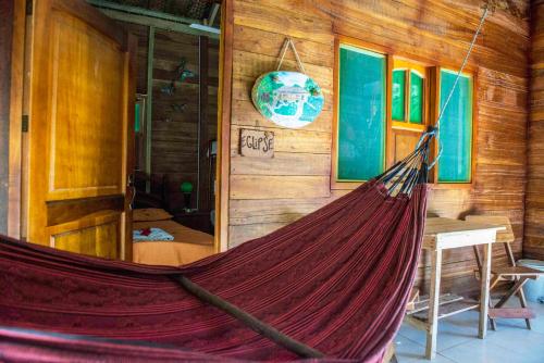 a hammock in a room in a wooden cabin at Posadas Ecoturisticas Seineken in El Zaino