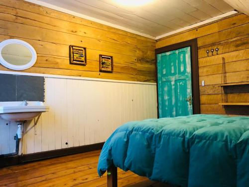 a bathroom with a sink and a bed in a room at Casa Apel Hostel in Puerto Varas
