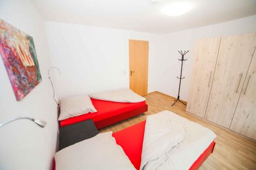 two beds in a room with red and white at Fewo Goldene Krone Leipzig mit Tiefgarage in Leipzig