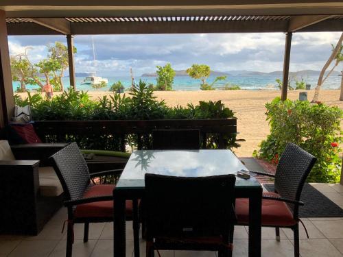 a table and chairs with a view of the beach at Ocean Front Sapphire del Mar B-107 in St Thomas