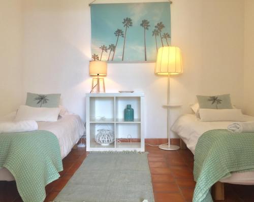 a room with two beds and a table with two lamps at Calanque in Cassis