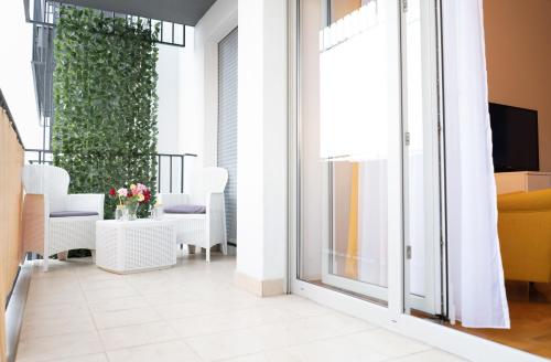 a room with a balcony with white chairs and a sliding glass door at Jacuzzi studio apartman Mare's in Zagreb
