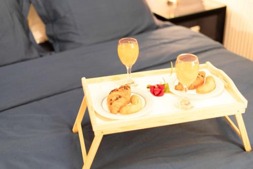 a tray with two glasses of orange juice and food on a bed at Jacuzzi studio apartman Mare's in Zagreb