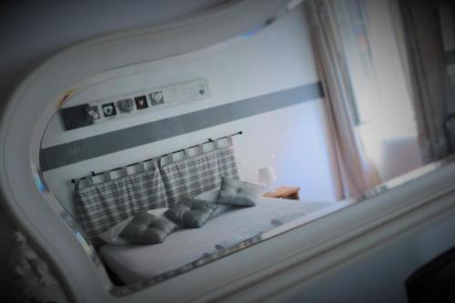 a reflection of a bed with pillows in a mirror at La Maison in Bergamo