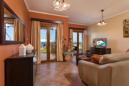a living room with a couch and a view of the ocean at Venetico Beachfront Apartments & Suites - 2 Bedroom Apartment in Argasi