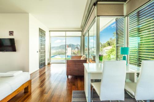 a bedroom with a living room with a table and chairs at Sirirat Sea-view Villa in Patong Beach