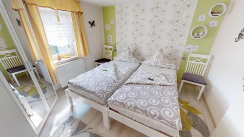 ein kleines Schlafzimmer mit einem Bett und einem Fenster in der Unterkunft Ferienwohnung Wild in Klingenthal