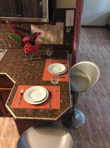 a dining table with two plates and glasses on it at Jamaica Dream Gateway in Richmond