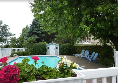 a swimming pool with flowers in a garden at Motel Belle Riviere in Saint-Jean-sur-Richelieu