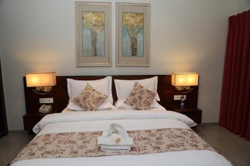 a bedroom with a large bed with two lamps at Hotel Moon Palace Kolwezi in Kolwezi