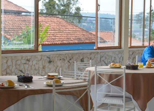 a restaurant with two tables with plates of food at Hotel Real São Lourenço in São Lourenço