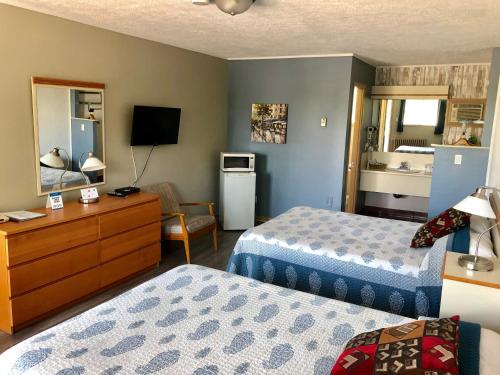 a hotel room with two beds and a television at Motel Belle Riviere in Saint-Jean-sur-Richelieu