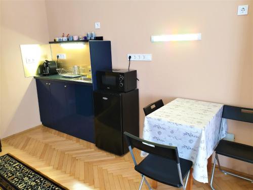 a kitchen with a table and a small table and chair at Madana apartman in Budapest