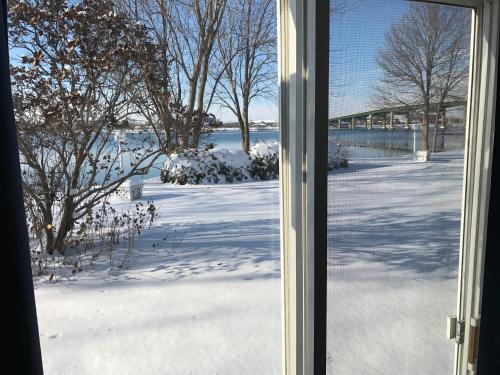 a window with a view of a snow covered yard at Motel Belle Riviere in Saint-Jean-sur-Richelieu