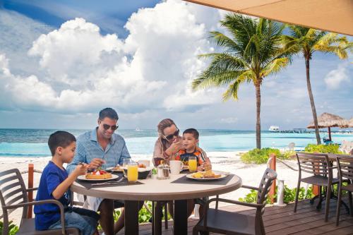 two men and a woman sitting at a picnic table at The Royal Cancun - All Suites Resort in Cancún