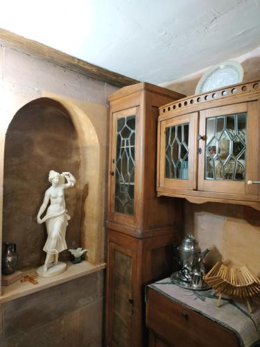 a kitchen with a cabinet and a statue of a woman at Hye Aspet Հայ Ասպետ in Gyumri