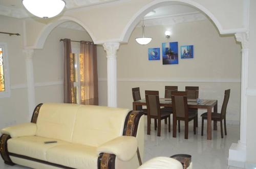 a living room with a couch and a table with chairs at Le VIP du Petit Génie in Yaoundé