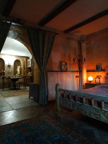 a bedroom with a bed and a room with a table at Hye Aspet Հայ Ասպետ in Gyumri